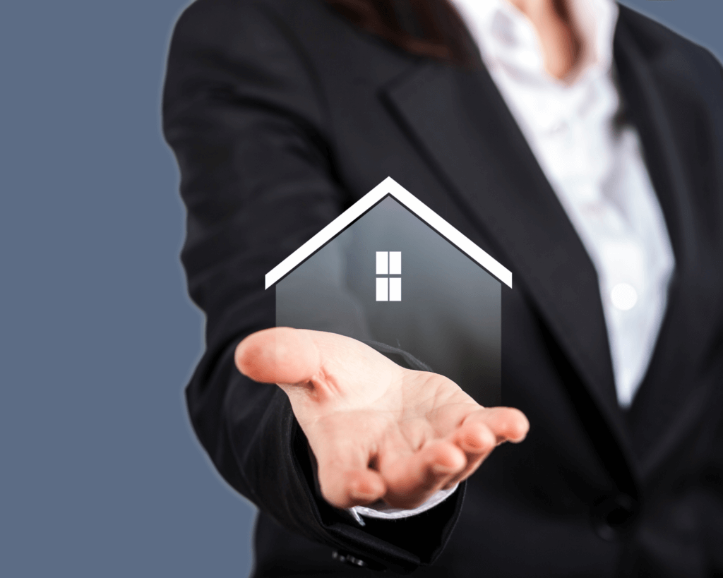 agent immobilier dont on voit la main au dessus de laquelle flotte un logo de maison , il est en costume et chemise blanche et on ne voit pas sa tête
